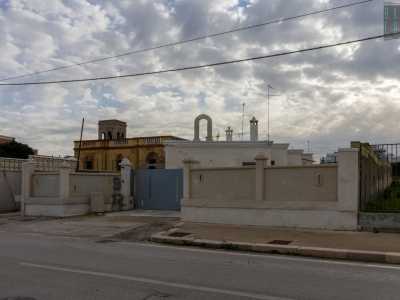 Riprendiamo dunque il nostro viaggio verso sud partendo dal lido �Il Trullo�. Dopo pochi passi, sulla nostra destra, incrociamo i primi edifici della zona: delle basse e bianche costruzioni in pietra con dei comignoli sul tetto e una specie di campanile ad arco